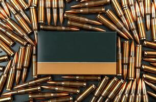 Background from rifle cartridges on a gray metal back. A box of cartridges. Copy space for text in the center of the image in the form of a rectangle. photo
