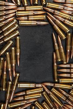 Background from rifle cartridges on a gray metal background. Copy space for text in the center of the image in the form of a rectangle photo