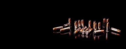 Shiny cartridges for the gun on a dark background. Ammunition for the gun. Pistol cartridges. Bullets and shell bullets on black. photo