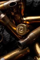 Empty shells from weapons on black smoldering coals. Consequences of the war. Dark back. photo