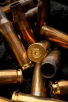 Empty shells from weapons on black smoldering coals. Consequences of the war. Dark back. photo
