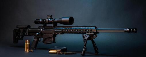 Modern powerful sniper rifle with a telescopic sight mounted on a bipod. Ammo and an additional magazine next to the rifle. photo