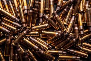 Background from empty cartridges for rifles and carbines. Shiny brass shells scattered on the surface. photo