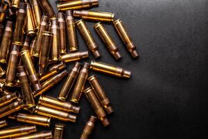 Background from empty cartridges for rifles and carbines. Shiny brass shells scattered on the surface. photo