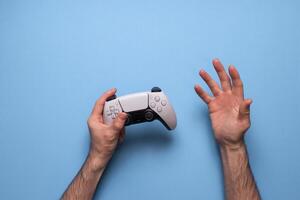 Hand hold new joystick. Gamer play game with gamepad controller. Gaming man holding simulator joypad. Person with keypad joystic in arms. Not understanding the situation. Gaming concept. photo