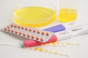 Urinalysis, urine cup with reagent strip pH paper test and comparison chart in laboratory. photo