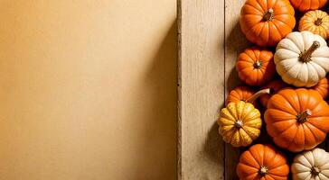 Wooden table with pumpkins of different sizes on soft cream background.Space for text. photo