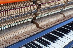 Inside a piano with keys, strings, pins and hammers photo
