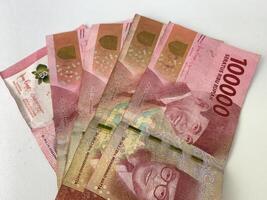 five pieces of Indonesian currency denomination of one hundred thousand rupiah. photo