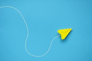 Top view of yellow paper airplane finding the right direction to fly. Exploring solution concept photo