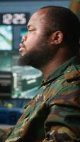 Vertical Soldiers working in governmental facility, doing surveillance with digital radar equipment, operating missile systems. Man monitoring army HQ CCTV for any unauthorized activity, camera A video