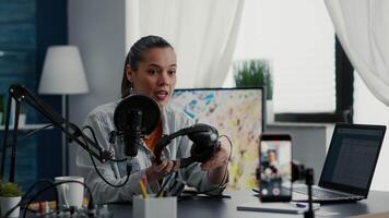 Tech product enthusiast reviewing modern headphones while recording with smartphone. Internet influencer presenting earphones specifications to public while doing recommendation video