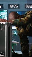 Vertical Military officers working together to check guns in command post, ensuring bullets and supplies are working properly. Team of soldiers holding pistol and rifles, managing combat load gear, camera A video