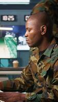 Vertical Portrait of military agent working in control room, analyzing aerial reconnaissance data. Intelligence corps agent controlling drones attacking strategic targets, camera B video
