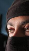 Vertical Terrorist hiding identity, attacking enemy command center. Close up of masked insurgent inspecting room during enemy base assault hijacking in guerilla warfare armed conflict, camera A video