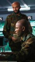 Vertical Team of military officers in command center look at intel folder files on enemy battle formation. Intelligence corps colleagues read mission case file to collect data on opponents strategy, camera B video