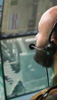Vertical Army specialist working in war room operating surveillance tech, evaluating target data. Close up on dispatcher doing job in HQ base of operations, engaging enemy forces, camera A video