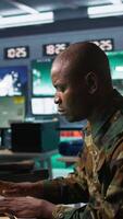 Vertical Army software developer employing AI tech in military planning and decision making. African american IT specialist uses artificial intelligence to enhance combat operational capabilities, camera B video