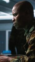 Vertical Army software developer employing AI tech in military planning and decision making. African american IT specialist uses artificial intelligence to enhance combat operational capabilities, camera A video