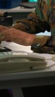 Vertical Military soldier in mission control center overseeing national safety operations with devices, close up. Middle Eastern army specialist examining data in monitoring room command center, camera A video