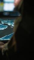 Vertical Army telecommunication systems operator using satellite software on tablet, providing combat support. Military dispatcher managing communications networks, with portable device, camera A video