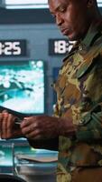Vertical Operatives conducing special operation, loading pistol, preparing to attack enemy troops. Close up of military unit in command center packing handgun for assault mission, camera A video