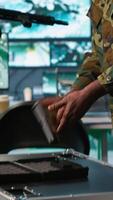 Vertical Team of army soldiers in command center packing weapons able to engage targets at extended range. Military units reloading gun cartridge, preparing for enemy assault mission, camera A video