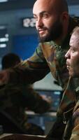 Vertical Air force officers performing tactical level reconnaissance in command post, looking at monitors. Military soldiers using radar devices to look at assault zones on displays, camera A video
