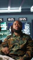 Vertical Military officer using augmented reality tracking tech to gain info helpful against enemies. Army expert using AR hologram to gain intel helping troops, coordinating mission activities, camera B video