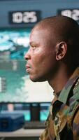Vertical Portrait of military agent working in control room, analyzing aerial reconnaissance data. Intelligence corps agent controlling drones attacking strategic targets, camera A video