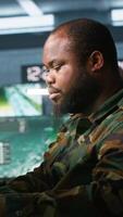 Vertical Air force officer and colleague performing tactical level surveillance in command post. Team of military specialists doing brainstorming, using radar equipment to look at assault zones, camera A video
