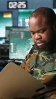 Vertical Military officer in command post receiving intel folder files on enemy battle formation. Intelligence specialist reading mission case file to collect data on opponents strategy, camera A video