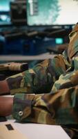 Vertical Officer doing tasks in military base, planning, analyzing and gathering information on enemy troops. Agent in base of operations doing assessment of enemy vulnerabilities, tracking, camera A video