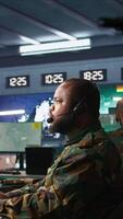 Vertical Army telecommunication systems operator providing combat support using gathered information on enemy troops. Military dispatcher managing communications networks in base of operations, camera B video