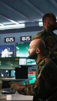 Vertical Soldier doing tasks in military base, doing surveillance with digital radar equipment, operating missile systems. Middle Eastern man monitoring army HQ CCTV for any unauthorized activity, camera B video
