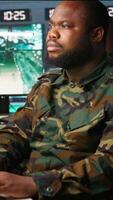 Vertical Counterintelligence specialist in military HQ base gathering information on enemy troops. African american agent in base of operations doing assessment of enemy vulnerabilities, tracking, camera B video