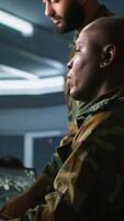 Vertical Army colleagues looking at screens in command center housing operational missile defense system designed to intercept ballistic rockets. Experts using tracking gear and radar systems, camera A video