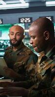 Vertical Teamworking military agents look at intel folder files on enemy battle formation. Intelligence corps coworkers read mission case documents to collect data on opponents strategy, camera B video