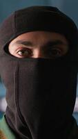 Vertical Portrait of terrorist loading gun, attacking enemy command center. Close up of masked insurgent reloading pistol during enemy base assault hijacking in guerilla warfare armed conflict, camera A video