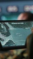 Vertical Military agent working in control room, using software on tablet, analyzing aerial reconnaissance data. Close up of intelligence corps expert controlling drones with portable device, camera A video