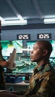 Vertical Soldier in military HQ base doing brainstorming with coworker, gathering information on enemy troops. Teamworking officers using tracking software to do assessment of enemy vulnerabilities, camera B video