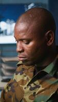 Vertical Army unit working in governmental facility next to coworker, doing brainstorming, operating surveillance tech. Team of soldiers doing job in HQ base of operations, camera A video