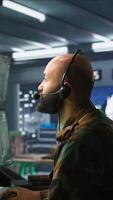 Vertical Army specialist working in war room operating surveillance tech, evaluating target data. Close up on dispatcher doing job in HQ base of operations, engaging enemy forces, camera B video
