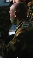 Vertical Army telecommunications operators using radio and satellite gear, inputting data on systems. Military dispatchers managing communications networks, typing on keyboard, camera A video