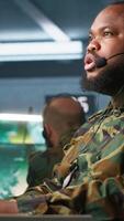 Vertical Army telecommunication systems operator providing combat support using gathered information on enemy troops. Military dispatcher managing communications networks in base of operations, camera A video