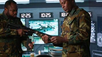 Operatives conducing special operation, loading pistol, preparing to attack enemy troops. Close up of military unit in command center packing handgun for assault mission, camera A video