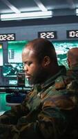 Vertical Military agents in war room look at intel folder files on enemy battle formation. Intelligence agency professionals read mission case file to collect data on opponents strategy, camera B video