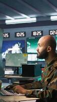 Vertical Soldier doing patriotic duty in military HQ base, gathering information on enemy troops. Officer using high tech monitoring gear to do assessment of enemy vulnerabilities, camera B video
