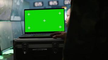 Military agent working in control room, using isolated screen software on laptop, analyzing aerial reconnaissance data. Intelligence corps expert controlling drones with mockup notebook, camera A video