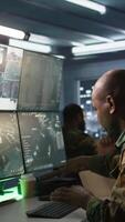 Vertical Army officers doing brainstorming in command center, looking at intel folder files. Intelligence corps experts read mission case paperwork to be informed on data on opponents strategy, camera B video